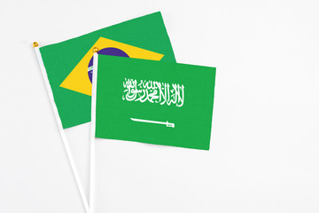 Naklejka na ściany i meble Saudi Arabia and Brazil stick flags on white background. High quality fabric, miniature national flag. Peaceful global concept.White floor for copy space.