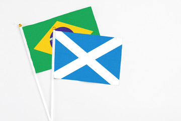 Scotland and Brazil stick flags on white background. High quality fabric, miniature national flag. Peaceful global concept.White floor for copy space.