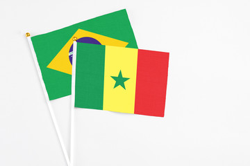 Senegal and Brazil stick flags on white background. High quality fabric, miniature national flag. Peaceful global concept.White floor for copy space.