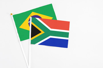 Fototapeta premium South Africa and Brazil stick flags on white background. High quality fabric, miniature national flag. Peaceful global concept.White floor for copy space.