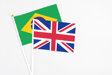 United Kingdom and Brazil stick flags on white background. High quality fabric, miniature national flag. Peaceful global concept.White floor for copy space.