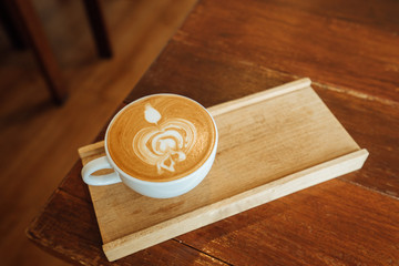 A delicious late art coffee on the wood table and blur background, Enjoy your Coffee break