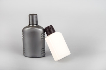 Gray and white bottles on a gray background. Cosmetic bottles. body care.