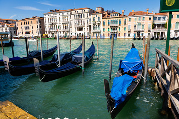 Fototapeta na wymiar Venetian gondolas moored in Grand Canal