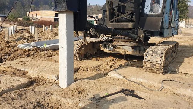 Machine drives into the ground piles construction. Construction of the Foundation of reinforced concrete structures.