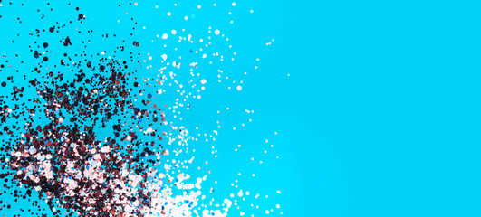 Festive confetti in the blue background, banner. Abstract blue surface with glitter sparkle, party invitation card. Holiday concept