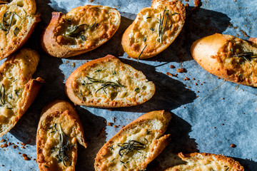 Garlic Parmesan Cheese Bread Slices on Baking Paper Sheet with Oven Tray. Freshly Baked.