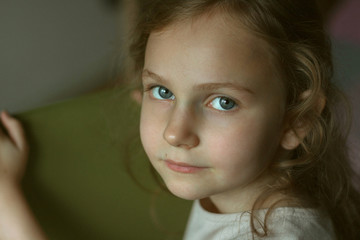  Portrait of a girl with big eyes and curly hair.