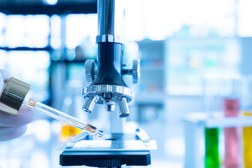 Close up Hand dropping water Put on the glass plate The Microscopes.The Scientists are dropping water droplets in vitro. That dropper on the glass tray.A Scientists are working in the laboratory