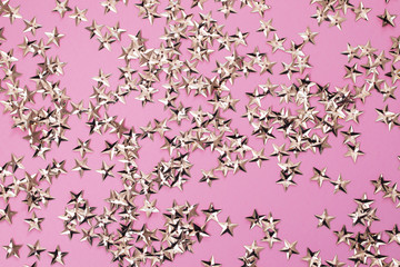 Obraz na płótnie Canvas small golden stars on pink background