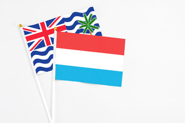 Luxembourg and British Indian Ocean Territory stick flags on white background. High quality fabric, miniature national flag. Peaceful global concept.White floor for copy space.
