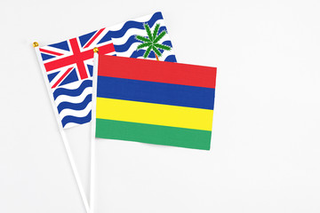 Mauritius and British Indian Ocean Territory stick flags on white background. High quality fabric, miniature national flag. Peaceful global concept.White floor for copy space.