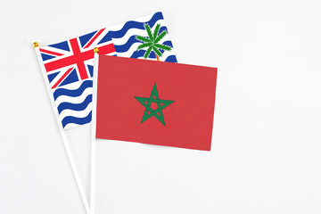 Morocco and British Indian Ocean Territory stick flags on white background. High quality fabric, miniature national flag. Peaceful global concept.White floor for copy space.