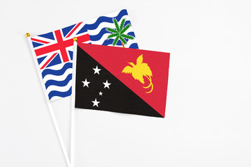 Papua New Guinea and British Indian Ocean Territory stick flags on white background. High quality fabric, miniature national flag. Peaceful global concept.White floor for copy space.