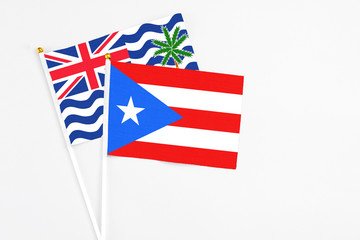 Puerto Rico and British Indian Ocean Territory stick flags on white background. High quality fabric, miniature national flag. Peaceful global concept.White floor for copy space.