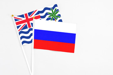 Russia and British Indian Ocean Territory stick flags on white background. High quality fabric, miniature national flag. Peaceful global concept.White floor for copy space.