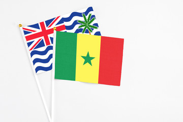 Senegal and British Indian Ocean Territory stick flags on white background. High quality fabric, miniature national flag. Peaceful global concept.White floor for copy space.
