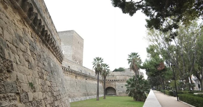 Walls of the Norman Swabian castle of Bari. The gardens with green plants and the fort built by Frederick II.