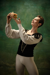 Young ballet dancer as a Snow White's character with burger in forest. Flexible caucasian ballet...