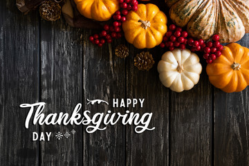 Top view of  Autumn maple leaves with Pumpkin, apple, corn and red berries on old wooden background. Thanksgiving day concept.