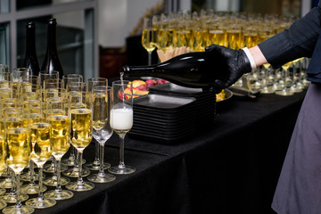 Waiter pours champagne into the glasses