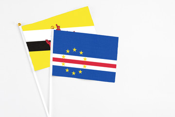 Cape Verde and Brunei stick flags on white background. High quality fabric, miniature national flag. Peaceful global concept.White floor for copy space.