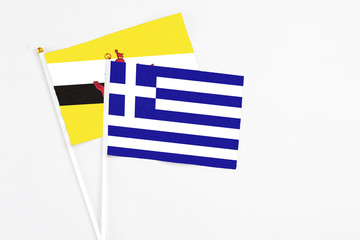 Greece and Brunei stick flags on white background. High quality fabric, miniature national flag. Peaceful global concept.White floor for copy space.