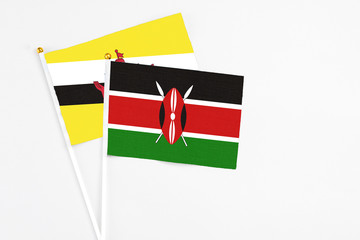 Kenya and Brunei stick flags on white background. High quality fabric, miniature national flag. Peaceful global concept.White floor for copy space.
