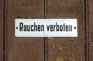 Alte verwitterte Tür mit Rauchen verboten Schild