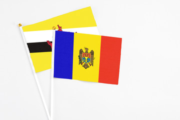Moldova and Brunei stick flags on white background. High quality fabric, miniature national flag. Peaceful global concept.White floor for copy space.