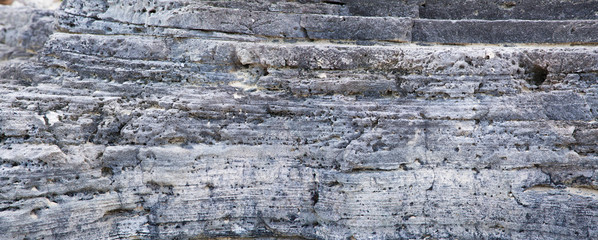     Layers of gray stone on the seashore. Panorama.