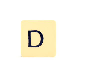 Dark letter D on a pale yellow square block isolated on white background