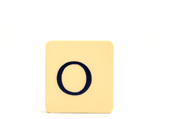 Dark letter O on a pale yellow square block isolated on white background