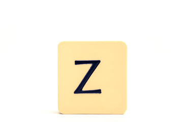 Dark letter Z on a pale yellow square block isolated on white background