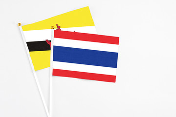Thailand and Brunei stick flags on white background. High quality fabric, miniature national flag. Peaceful global concept.White floor for copy space.