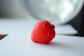 red plastic strawberry on a white background