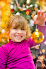 Fototapeta na wymiar pretty little girl in front admiring Christmas decoration