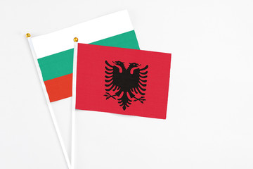 Albania and Bulgaria stick flags on white background. High quality fabric, miniature national flag. Peaceful global concept.White floor for copy space.