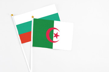 Algeria and Bulgaria stick flags on white background. High quality fabric, miniature national flag. Peaceful global concept.White floor for copy space.