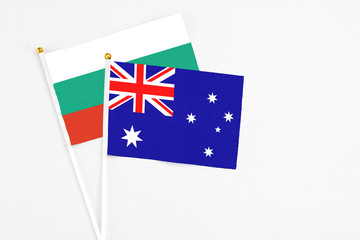Fototapeta premium Australia and Bulgaria stick flags on white background. High quality fabric, miniature national flag. Peaceful global concept.White floor for copy space.