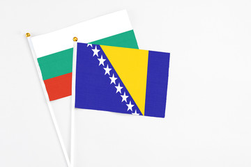 Bosnia Herzegovina and Bulgaria stick flags on white background. High quality fabric, miniature national flag. Peaceful global concept.White floor for copy space.