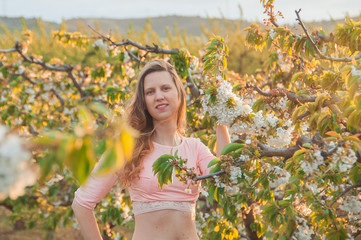 Mujer joven en campo de cerezos, flores