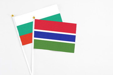 Gambia and Bulgaria stick flags on white background. High quality fabric, miniature national flag. Peaceful global concept.White floor for copy space.