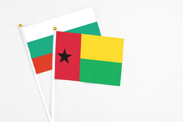 Guinea Bissau and Bulgaria stick flags on white background. High quality fabric, miniature national flag. Peaceful global concept.White floor for copy space.