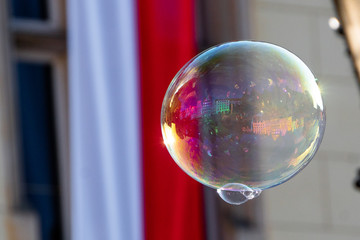 Close up of the colorful soap bubble in the bright autumn day with polish national flag during independence in Wroclaw,