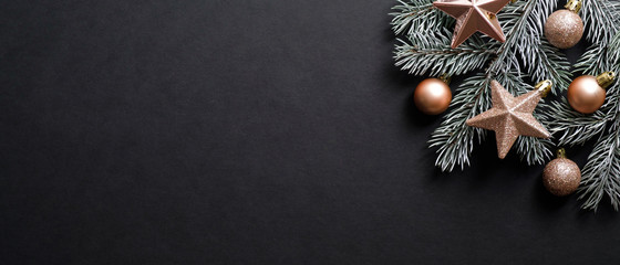 Christmas banner. Black Xmas background with pine tree branch decorated cooper color balls and...