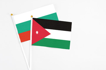 Jordan and Bulgaria stick flags on white background. High quality fabric, miniature national flag. Peaceful global concept.White floor for copy space.