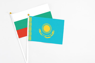 Kazakhstan and Bulgaria stick flags on white background. High quality fabric, miniature national flag. Peaceful global concept.White floor for copy space.