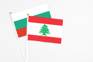 Lebanon and Bulgaria stick flags on white background. High quality fabric, miniature national flag. Peaceful global concept.White floor for copy space.