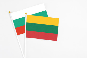 Lithuania and Bulgaria stick flags on white background. High quality fabric, miniature national flag. Peaceful global concept.White floor for copy space.